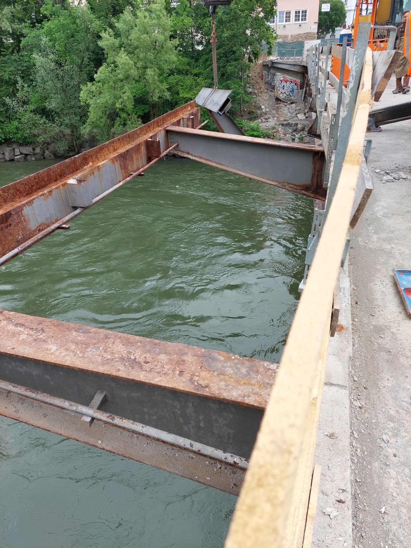 Geöffneter Stahlkasten einer Brücke im Fluss, Träger noch nicht abtransportiert.