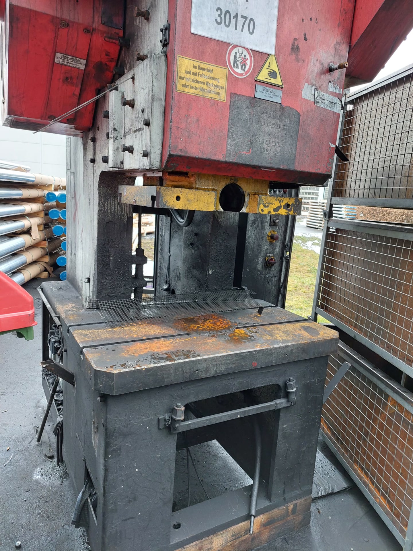 Rote Exzenterpresse im Hof, noch als ganze Maschine.